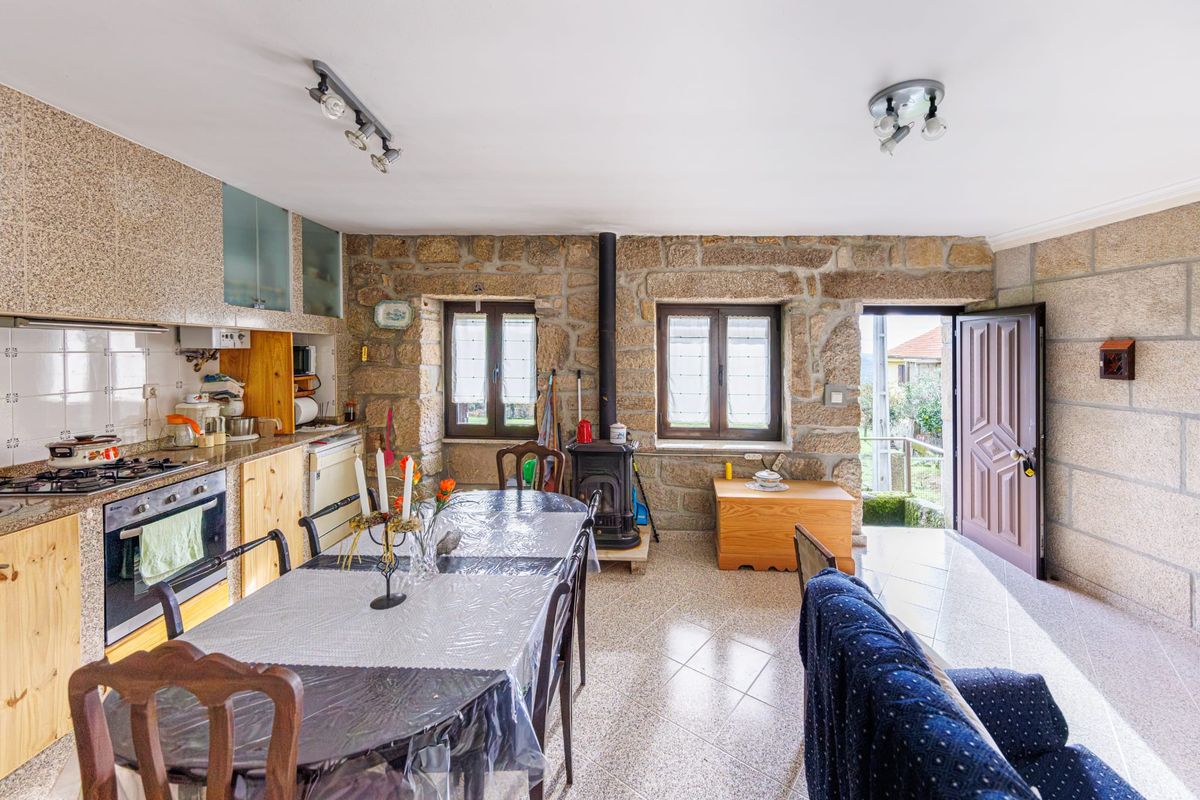 Cozinha equipada com placa, forno e exaustor, vista da sala
