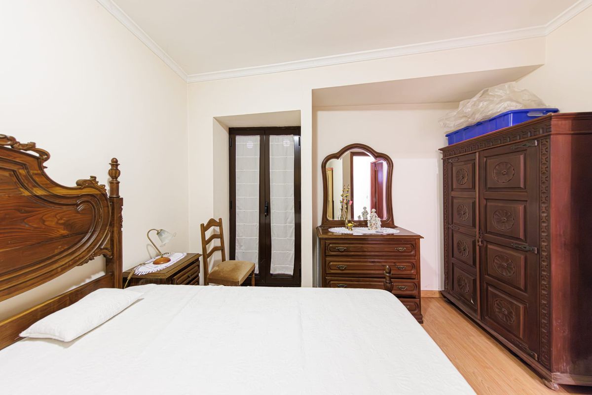 Primeiro quarto, mobilado, com cama de casal, cómoda com espelho e roupeiro