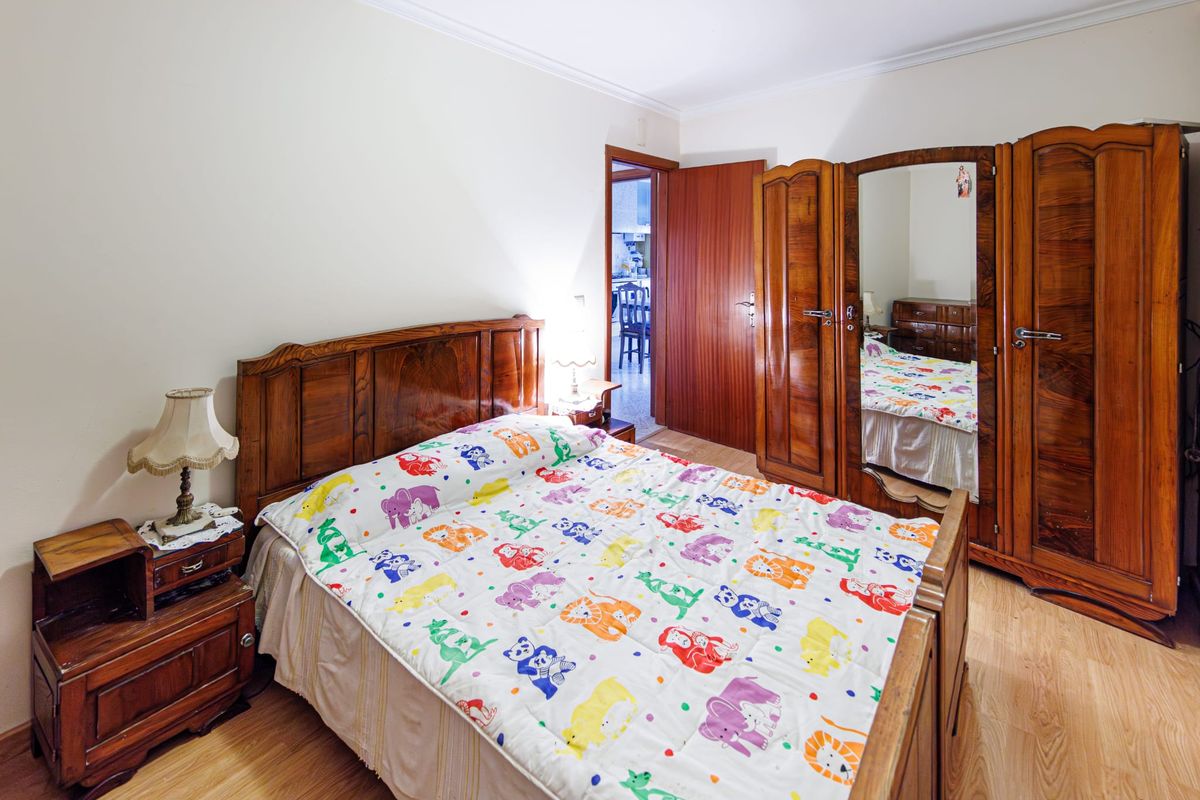 Segundo quarto, com roupeiro de espelho e porta para o corredor